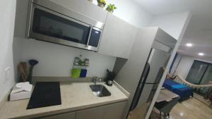 a small kitchen with a sink and a microwave at Estudio de playa Monpal in Playa del Carmen