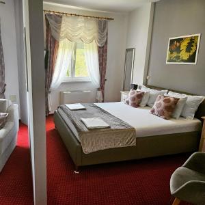 a bedroom with a large bed with a window at Hotel Villa Valpovo in Valpovo