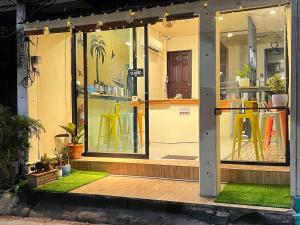 a store front with yellow tables and chairs inside at The Cocoon Hostel in Ko Samed