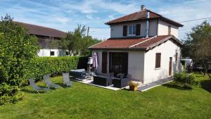 a small white house with chairs in a yard at L'échappée Dervoise in Montier-en-Der