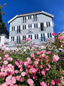 a white building with pink roses in front of it at Kragerø Hotell in Kragerø +40 photos