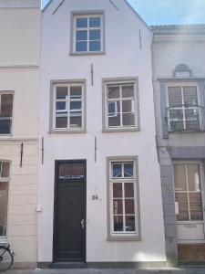 a white house with a black door and windows at Historisches Kontorhaus, Zentral, 2Zi., Netflix! in Emden