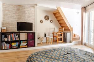 a bedroom with a tv and a brick wall at LA ROUSSETTE in Marseillan