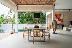 a kitchen and dining room with a table and chairs at Rouge - Loft Emylia in Ubud