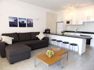 a living room with a couch and a kitchen at Apartamentos Medano - Estrella del Mar in El Médano