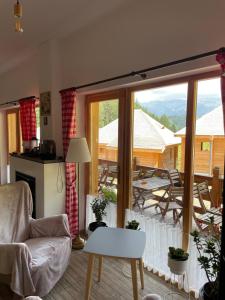 a living room with a large window and a table and chairs at Andolia in Moieciu de Sus