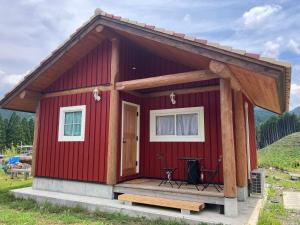 a red tiny house with a porch and a table at Guesthouse EL CAMPO in Gokase