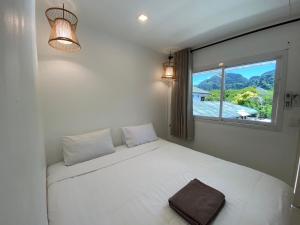 ein Schlafzimmer mit einem weißen Bett und einem Fenster in der Unterkunft BB Hidden House in Ko Phi Phi