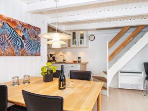 a dining room with a table and a staircase at Holiday home Hemmet LI in Hemmet
