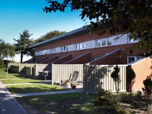 a red brick building with a white fence at Holiday home Hemmet LI in Hemmet