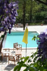 una sombrilla amarilla y sillas junto a la piscina en Agriturismo Ca' Montioni, en Mercatello sul Metauro