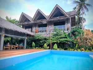 a villa with a swimming pool in front of a house at The Ohm Siargao Resort in General Luna
