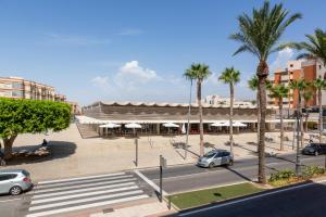 una calle con coches aparcados delante de un edificio en Hostal Moya, en Roquetas de Mar