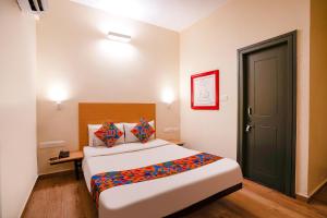 a bedroom with a large bed and a black door at Via Royal Sterling in Bengaluru