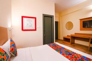 a hotel room with a bed and a television at FabExpress Royal Sterling - Nr Manyata Tech Park in Bengaluru