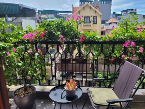 a balcony with potted plants and a table and chairs at The Delice house near Train street, old Quarter in Hanoi