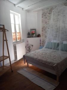 a bedroom with a bed and a ladder in it at La maison aux livres in Rioux-Martin