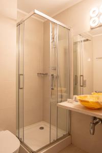 eine Glasdusche in einem Badezimmer mit Waschbecken in der Unterkunft Hotel Dorna in Mamaia + 80 Fotos