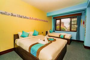 ein Hotelzimmer mit zwei Betten mit einer Frau darauf in der Unterkunft Rest Up Thamel Hostel in Kathmandu