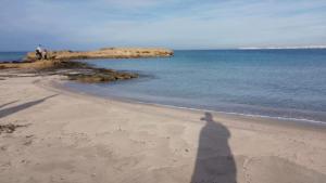 a shadow of a person standing on the beach at Casa Vacanza Ada, A 2 Minuti Dal Mare, Relax Per Coppie in Marina di Mancaversa