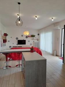 kuchnia i salon ze stołem i czerwonymi krzesłami w obiekcie La casa dei butei w mieście Castelnuovo del Garda