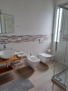 łazienka z 2 umywalkami, toaletą i prysznicem w obiekcie La casa dei butei w mieście Castelnuovo del Garda +15 zdjęć