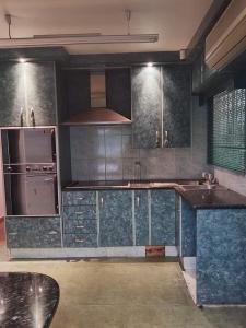 a kitchen with stainless steel appliances and blue cabinets at Protea Guest house in Ladysmith