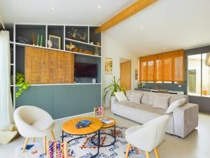 a living room with a couch and a table and chairs at Villa d'architecte avec Piscine chauffée et jardin in Rivedoux-Plage