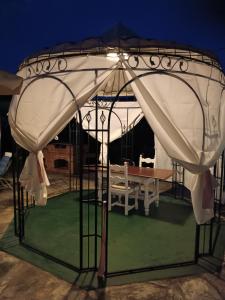 a gazebo with a table under it at night at B&B Casa dell'Orso in Lurisia