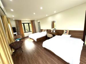 um quarto de hotel com duas camas e uma escrivaninha em Hà Thành Villa em Hanói mais 58 fotografias