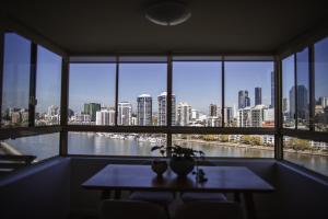 Cette chambre dispose d'une table et offre une vue sur la ville. dans l'établissement Riverfront Residences New Farm, à Brisbane