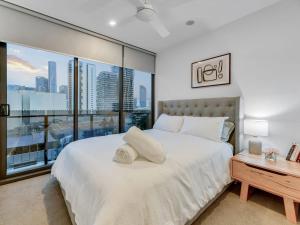 a bedroom with a white bed and a large window at Resort Living 2BR with Pool Spa Gym & Parking in Brisbane +26 photos