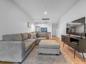 a living room with a couch and a table at Resort Living 2BR with Pool Spa Gym & Parking in Brisbane