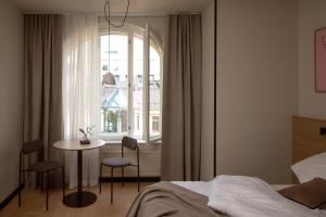 a bedroom with a bed and a table and a window at Bob W Helsinki Kaarti in Helsinki