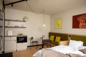 a bedroom with a bed and a kitchen with a table at Bob W Helsinki Kaarti in Helsinki