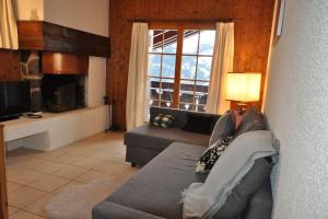 a living room with a couch and a large window at Dauphinelles 12 in Gryon