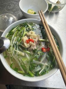 a bowl of soup with vegetables and chopsticks on a table at Tuyên Quang 301TK27 in Hanoi