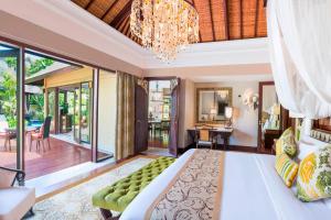 a bedroom with a large bed and a chandelier at The St. Regis Bali Resort in Nusa Dua
