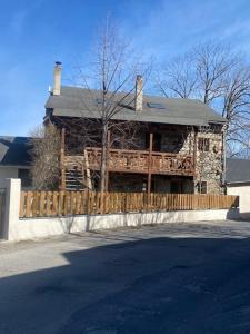 una casa con una valla de madera delante de ella en Appartement avec vue et jardin, en Formiguères