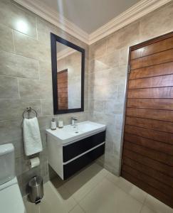 a bathroom with a sink and a mirror and a toilet at Hornbill Self Catering Cottages Muldersdrift in Krugersdorp +15 photos