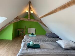 a bedroom with two beds and a green wall at Ecuries Tourangelles in Bréhémont