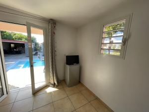 a living room with a television and a sliding glass door at Kaz Mont Vert in Saint-Pierre