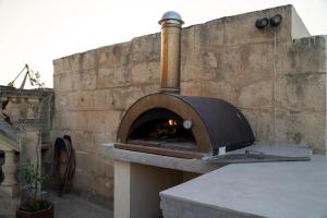 a pizza oven sitting on top of a brick wall at Palazzo Leone - 3 Cities Luxury in Senglea