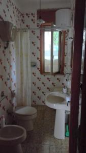 a bathroom with two sinks and a toilet at Villetta indipendente a soli 200 metri dal mare in Torre dell'Orso +12 photos