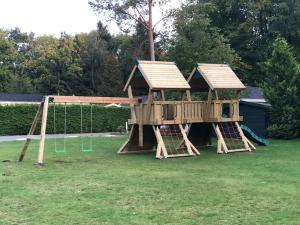 a wooden play house with a swing at Forest Cottage Hattem in Hattemerbroek