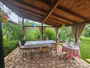 a table and chairs sitting under a pavilion at Villa Sara - Apartments & Garden, Kratovo in Kratovo