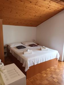 a large bed in a room with a wooden ceiling at Apartment Mrkić in Biograd na Moru