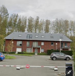 Un edificio con techo solar en un estacionamiento. en Appartement proche plage et CNPE, en Gravelines