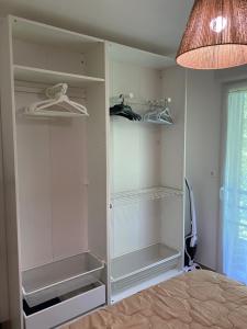 Un armario blanco con estantes y una lámpara. en Appartement proche plage et CNPE, en Gravelines