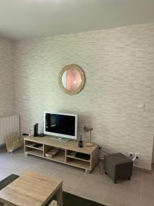 Una sala de estar con un televisor de pantalla plana en una pared. en Appartement proche plage et CNPE, en Gravelines